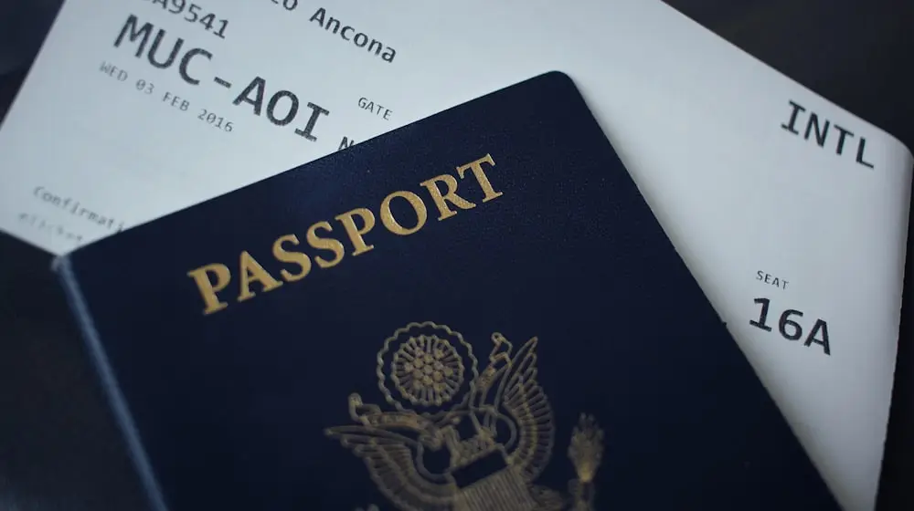 A navy passport lying across two printed boarding passes on a dark desk.